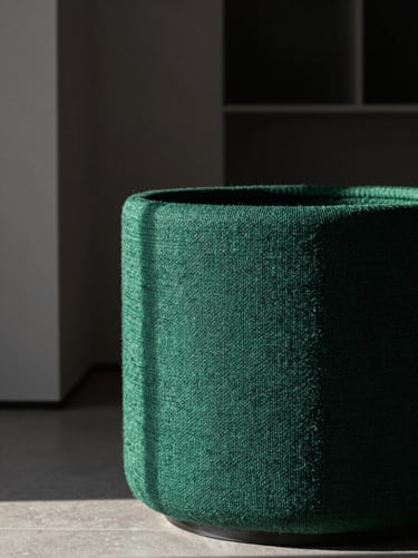 Close-up of a textured emerald green fiber planter in a minimalist modern villa, dramatic side-lighting, high contrast