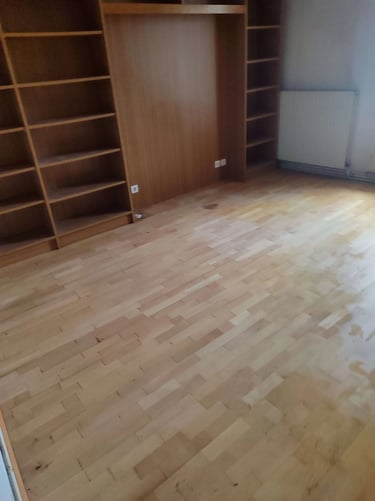 Débarras Lepeltier - Intérieur d'une pièce avec un parquet en bois et des étagères vides.