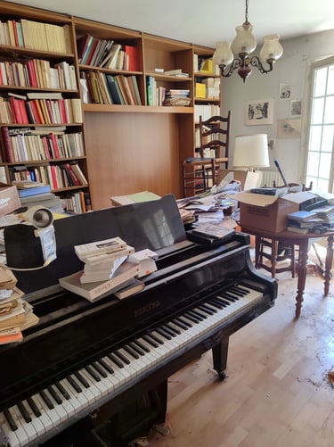 Débarras Lepeltier - Un piano noir élégant placé dans une pièce lumineuse avec des murs clairs et un sol en bois.