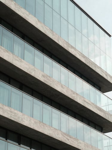 Sharp architectural detail of a high-performance double-glazed glass facade in Noida, deep concrete shading structures, 24mm.