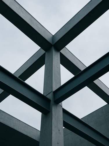 Low-angle architectural shot of structural concrete and steel beams against a cool overcast sky, sharp geometric lines and shadows, 35mm lens