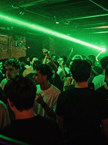 Wide-angle action shot of a sweat-drenched crowd in motion under intense acid green strobe lights, raw brick walls, heavy film grain