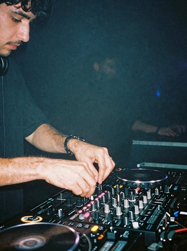 Gritty flash photography of DJ hands adjusting a mixer dial, glowing hot pink LED level meters, thick warehouse haze, raw underground club energy