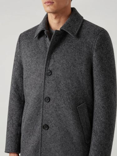 Editorial portrait of structured men's wool coat in charcoal, studio lighting, clean lines