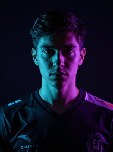 Dramatic low-key portrait of a professional esports player in a dark jersey, sharp cyan rim lighting, deep shadows, looking intensely forward