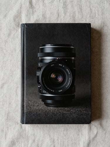 Overhead flat-lay of a thick paperback on a pale linen surface, diffused daylight, even shadows, no text visible on cover