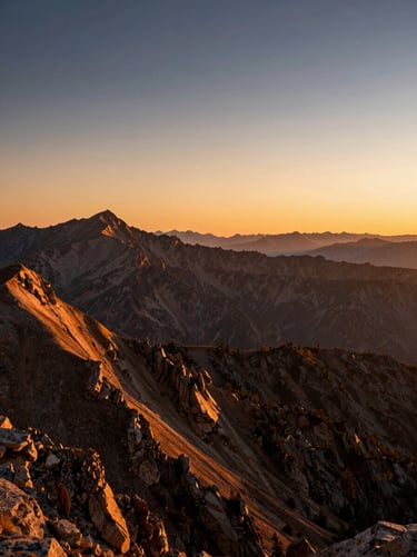 Sweeping panoramic mountain landscape at golden hour, deep orange and blue sky gradient, sharp details