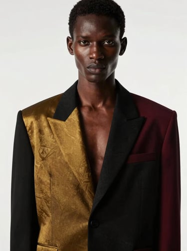 High-fashion editorial portrait of an African model posing in a structured modern black and gold blazer, dramatic studio lighting, 85mm