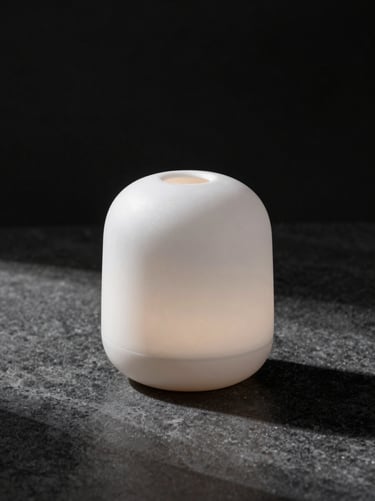 Minimalist ceramic diffuser on a dark stone surface, elegant shadows, luxury interior