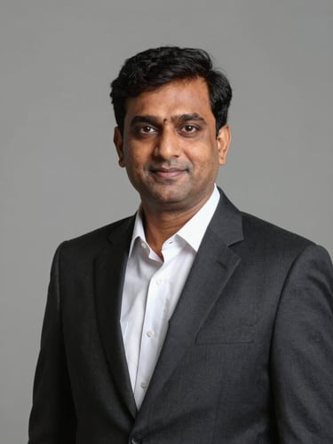 Dignified formal portrait of an Indian male legal professional in a dark suit and white shirt, neutral background, professional studio lighting, centered framing.