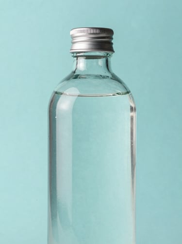 Sleek 1000ml glass bottle with a premium silver cap, pristine water transparency, sharp focus, cool aqua tones.