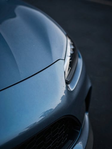 Macro shot of liquid-like paint reflections on a metallic blue fender, showing flawless depth and zero orange peel, dramatic studio light, 35mm