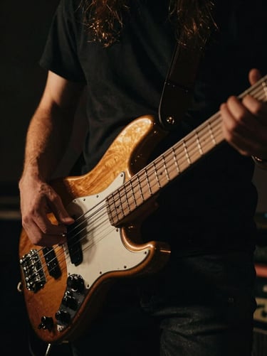 Close-up of hands playing a bass guitar in a low-key lit studio, warm golden accents, deep shadows, cinematic atmosphere
