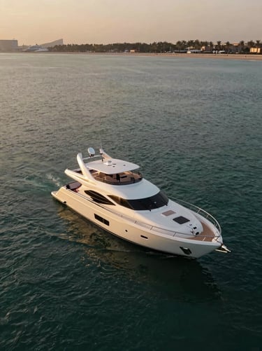 Dramatic aerial perspective of a private yacht anchored in the calm, deep turquoise lagoons of Palm Jumeirah during golden hour.