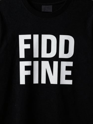 High-contrast product shot of a minimalist black t-shirt with bold white typography, low-key studio lighting, 35mm film texture.