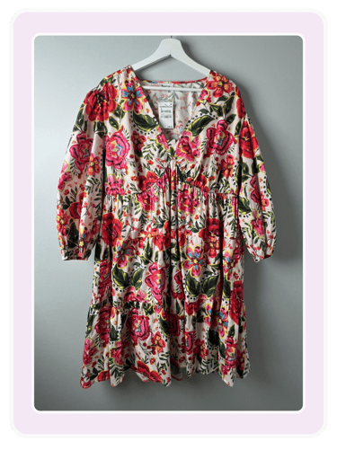 Floral print long sleeve mini dress with a V-neck and ruffled tiers on a white hanger.