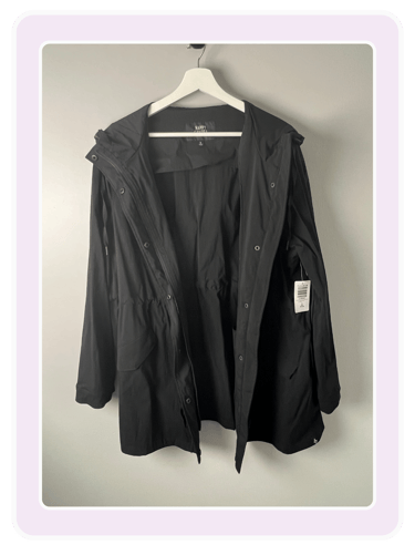 Happy Camper by Torrid jacket for women hanging on a white hanger against a grey wall.