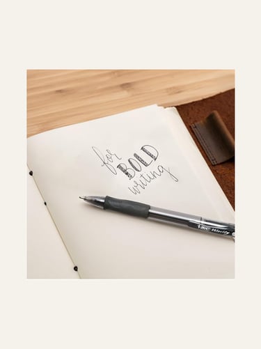 picture of a black bic pen on a open notebook with "for bold writing" written on page