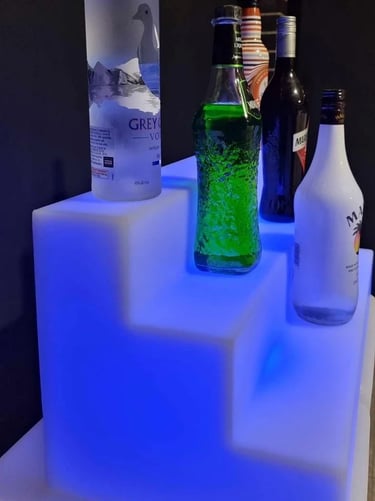 Blue glow drink stand with bottles of alcohol, accessory to glow bar in Redlands.