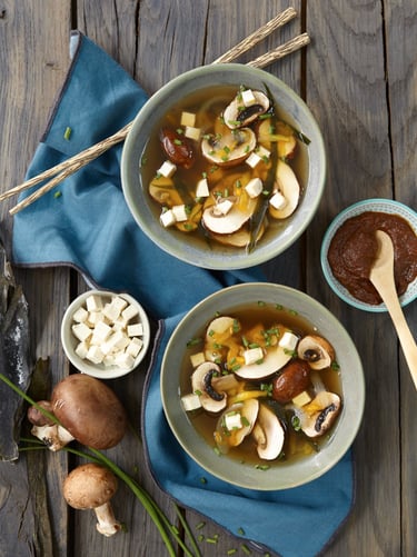 a couple of bowls of soup with mushrooms and mushrooms
