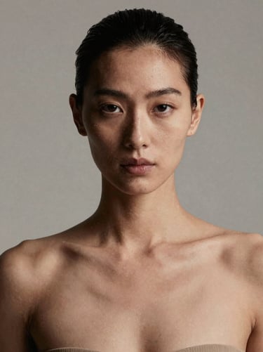High contrast editorial studio portrait of a female model, neutral background, sharp lighting