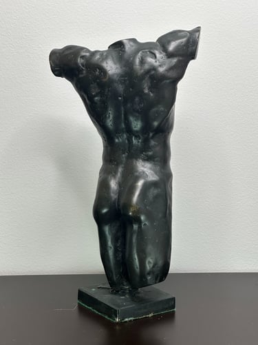 a sculpture of a man's torso from the rear