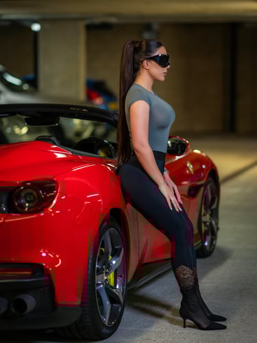 Model standing confidently by red Ferrari in sleek outfit, photographed by Fred Art Studio.