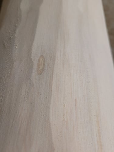 Close-up of smooth light-colored wood grain texture on a natural lumber plank.