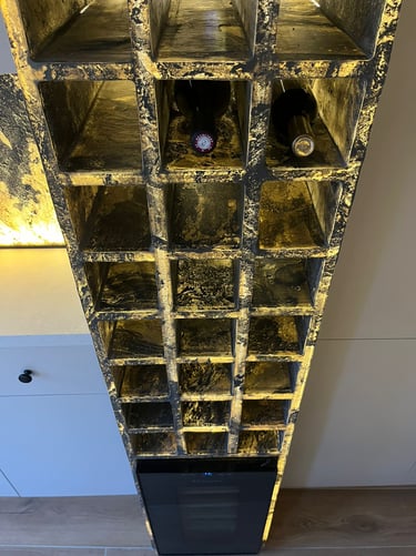 Custom stone wine rack with LED backlighting and two bottles of red wine stored in a luxury kitchen.