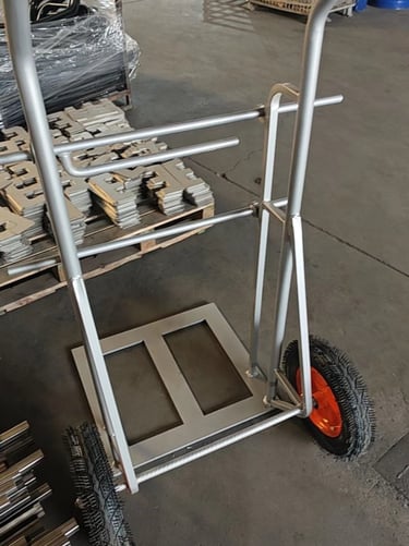 Heavy-duty steel industrial hand truck with pneumatic tires on a warehouse floor.