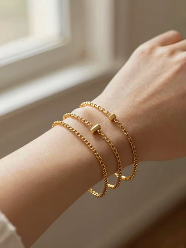 Gold chain bracelets stacked elegantly on a wrist, warm diffused light