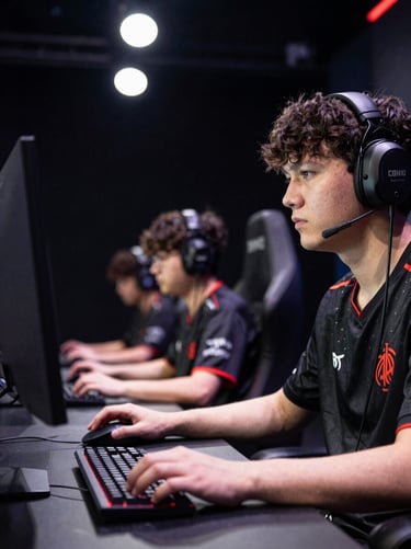 Competitive esports player at a lit tournament stage, focused gaze directed at monitor, hands on mouse and keyboard, high-contrast arena overhead lighting, dark background