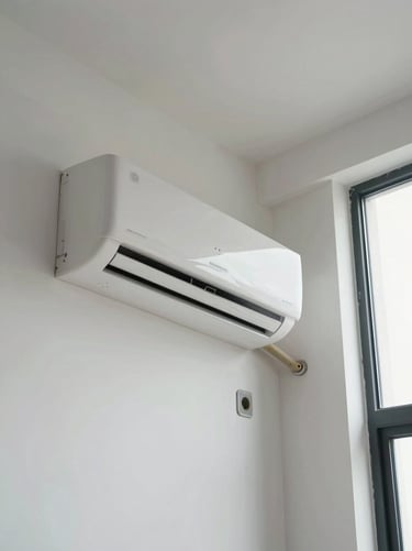 Wide shot of a newly installed wall-mounted split AC unit fixed to a clean interior wall, electrical conduit and refrigerant lines neatly dressed against the wall surface, daylight from a window to the right illuminating the unit face and the surrounding wall in clinical detail, no people in frame