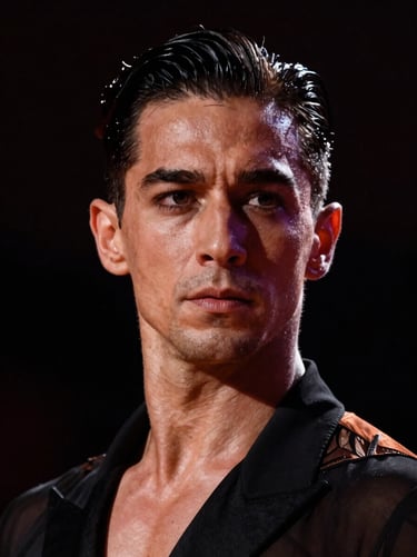 Dramatic portrait of a male ballroom dancer, focused expression, warm stage light cutting through darkness, high contrast.