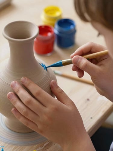 Close-up of a child's hands carefully painting a ceramic vase, colorful paint jars in the background, soft warm lighting.