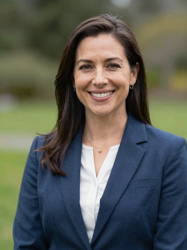 Professional headshot of a female insurance advisor, natural outdoor lighting, soft depth of field, friendly expression.