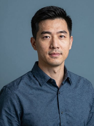 Professional headshot of a male insurance advisor, clean slate blue background, soft natural lighting, looking trustworthy.