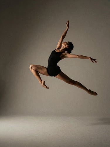Dynamic action crop of a dancer leaping, dramatic shadows on a warm gray background, high contrast, 35mm film grain
