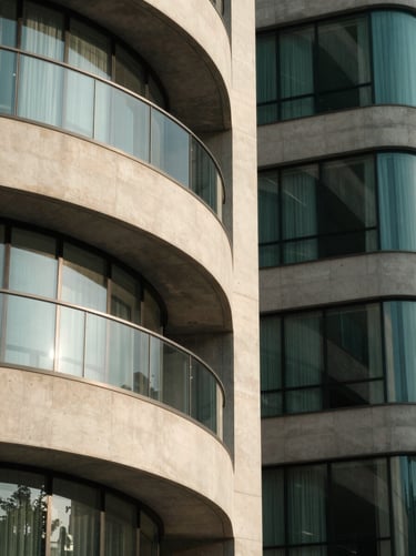 Abstract architectural details of a modern financial hub, concrete and glass curves, soft morning light, deep forest green tones, minimal composition