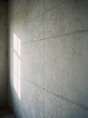 Weathered concrete wall of an abandoned building, soft natural side light, 35mm grain.