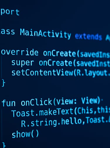 Close-up of a code editor showing clean Kotlin syntax highlighting, ambient frosty blue light reflecting on the monitor screen