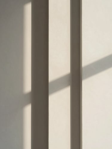 Close-up of clean architectural lines and abstract window shadows on a smooth ivory plaster wall, minimalist editorial, soft daylight.