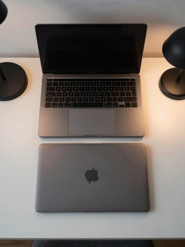 Overhead flat lay of a minimalist desk setup, featuring a matte-black laptop, clean desk mat, and a single desk lamp casting warm diffused light, professional and highly structured composition.