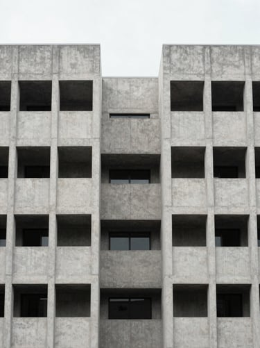 Symmetrical architectural elevation of a modern concrete building envelope, overcast daylight, sharp structural lines, 35mm.