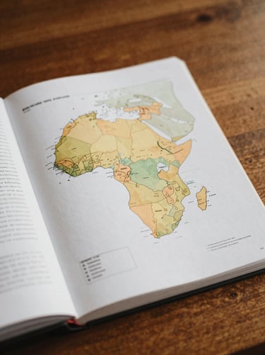 An intelligence brief document open on a wooden desk, showing detailed data maps of Africa with highlighted risk zones, natural soft lighting, precise editorial feel.