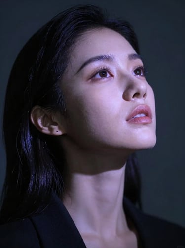 Cinematic low-angle shot of a woman looking upward, soft volumetric projection of lavender light on her face, dark atmosphere