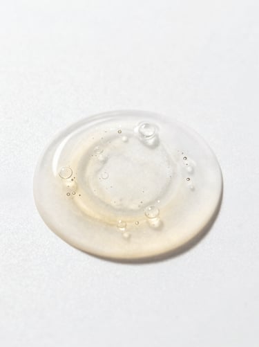 Macro shot of a clear cosmetic gel with tiny air bubbles, bright high-key studio lighting with elegant shadows, 85mm