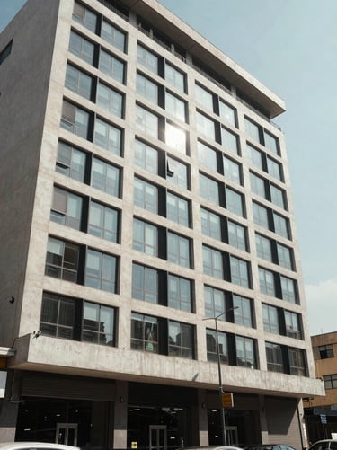 Wide shot of a Lagos commercial property facade at midday, clean concrete and glass exterior, street-level perspective, natural daylight, no people, architectural documentation style