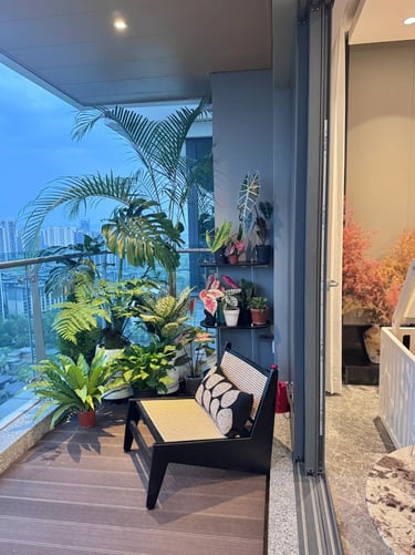 Small balcony retreat with natural materials, potted plants, soft cushions, and warm ambient lightin