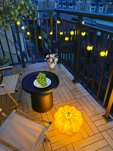 Cozy small balcony with space-saving furniture, soft cushions, potted plants, and warm evening light.